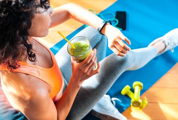 A woman enjoying a healthy smoothie between exercises